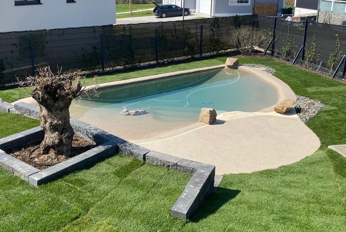 BIOdesign-Pool mit Strandbereich und Findlingen