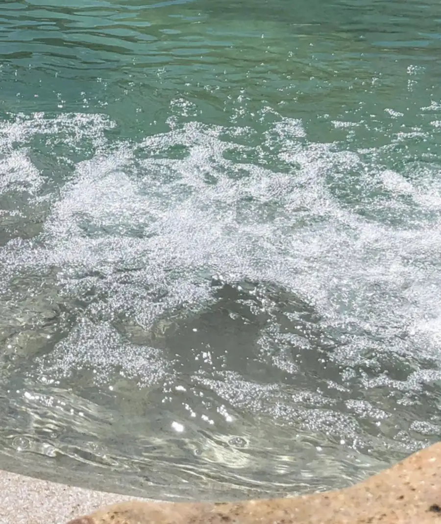 Sprudelnde Unterwassermassage im BIOdesign-Pool neben Naturstein
