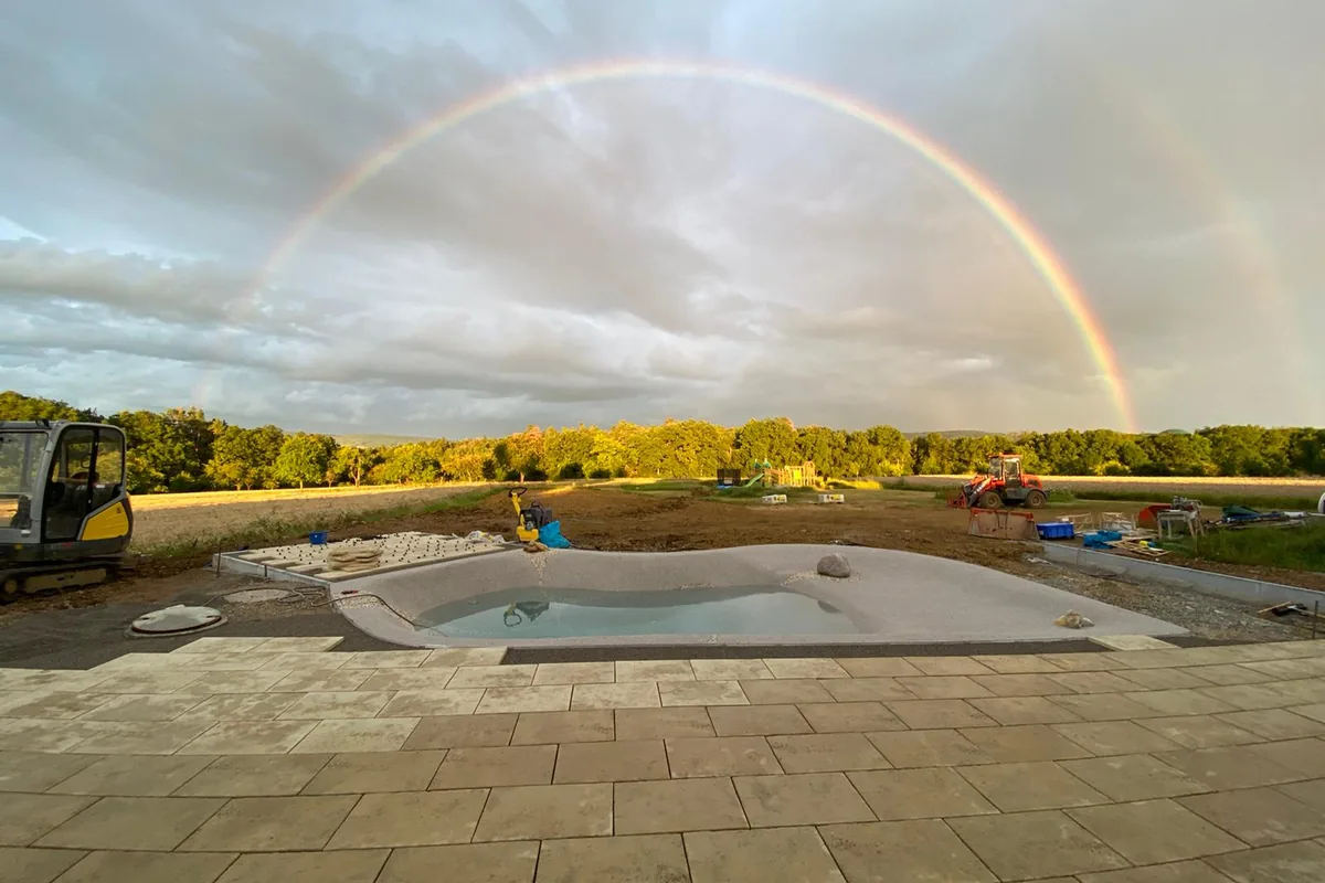 Regenbogen über einer Pool-Baustelle kurz vor der Fertigstellung