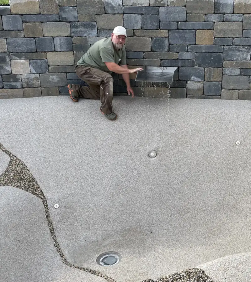 Bei der Arbeit an einem BIOdesign-Pool vor einer Natursteinmauer